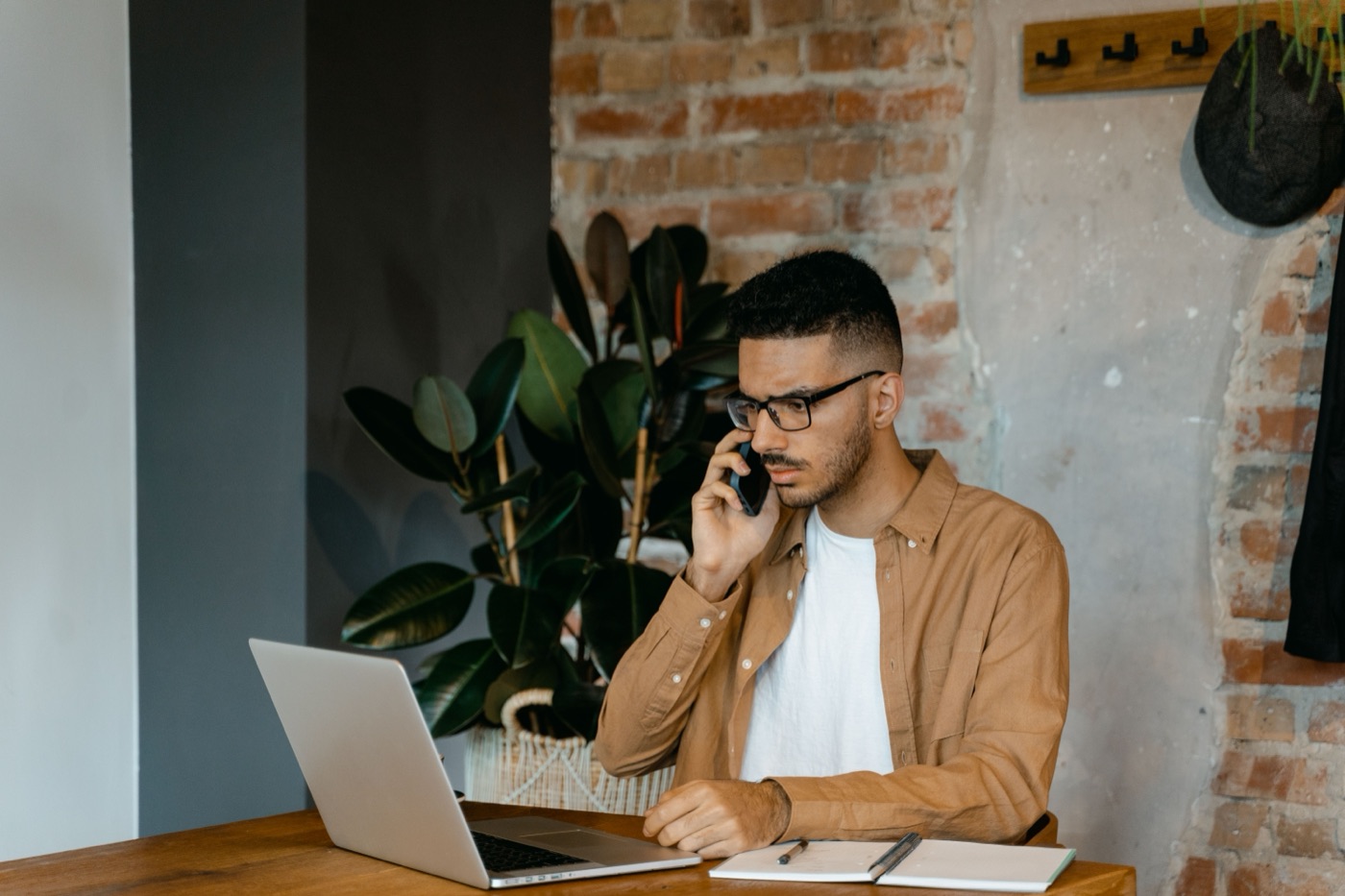 A landlord on the phone at his desk, brick wall behind him
